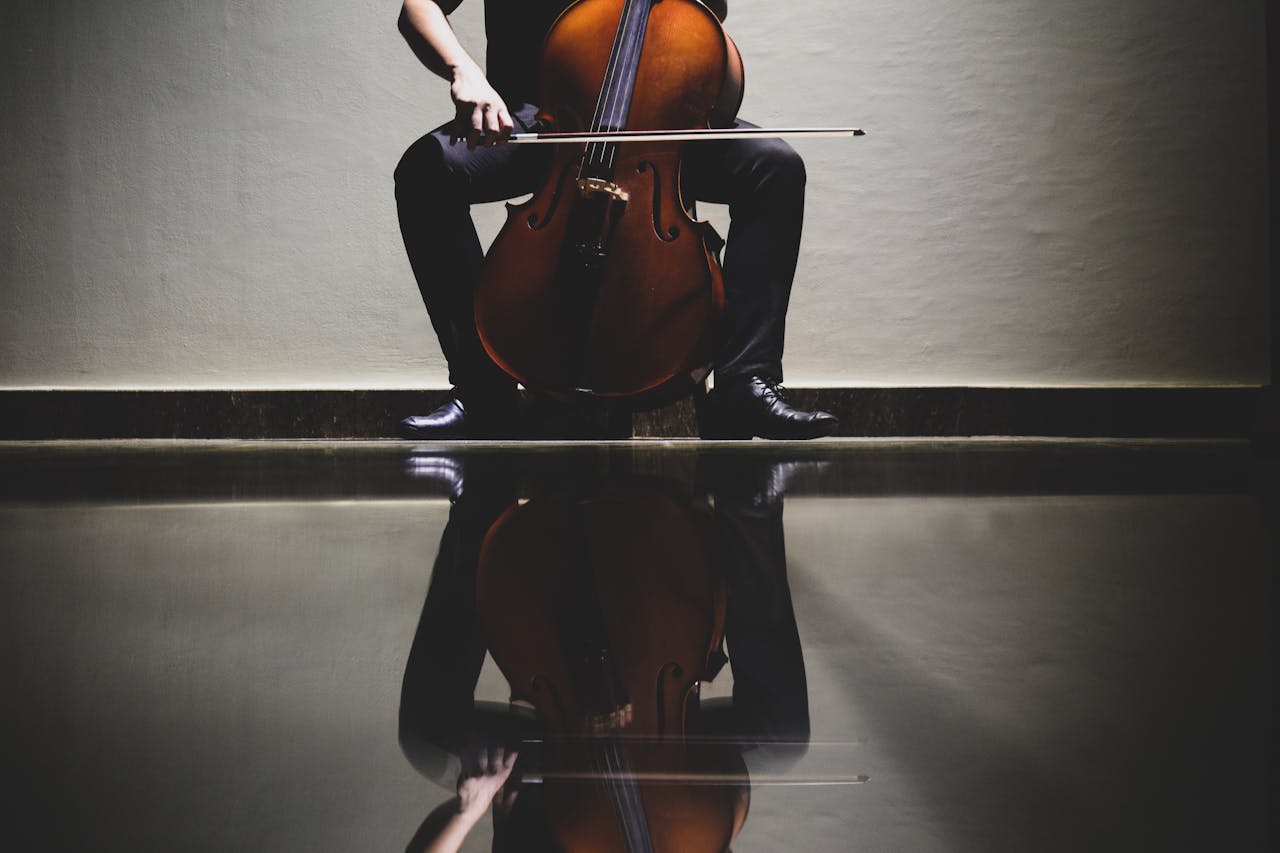 about-03 Elegant reflection of a cellist playing a cello in an indoor setting, emphasizing classical music themes.