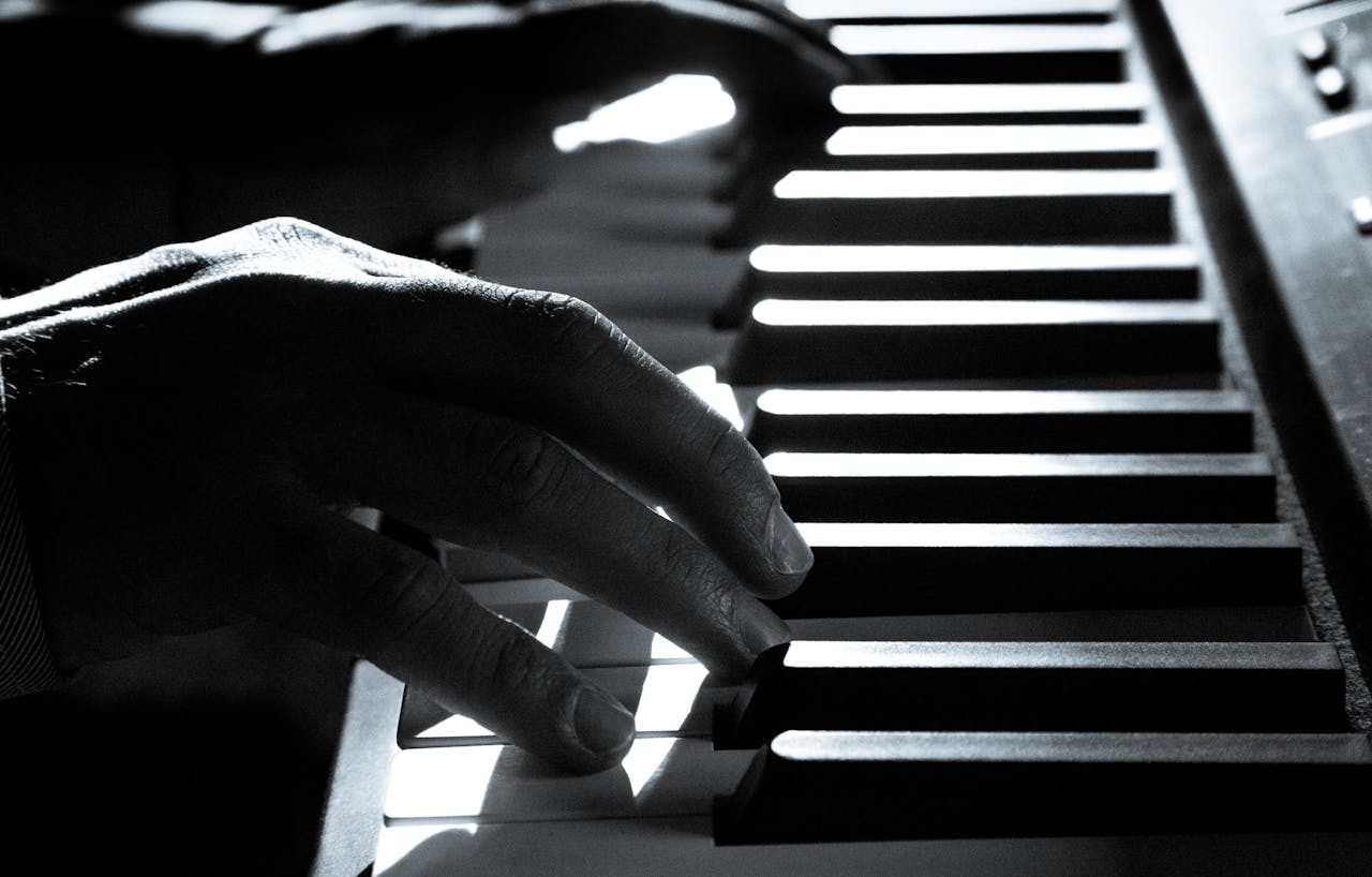 Artistic black and white photo capturing a pianist's hands on piano keys, highlighting music's emotion.